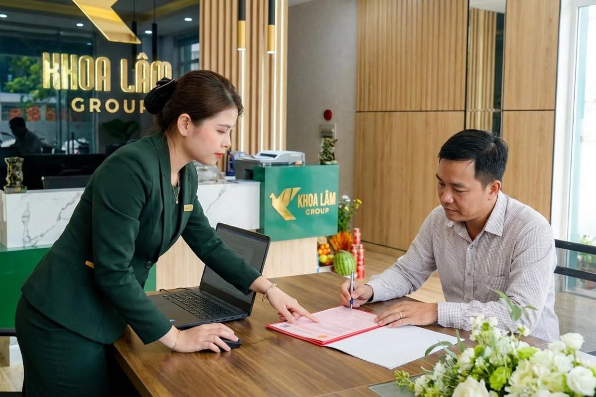 Khách hàng ký hồ sơ bàn giao sổ hồng tại văn phòng Khoa Lâm Group